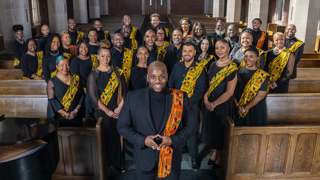Gospel choir stands together in a church.