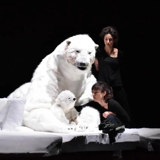 Photo of puppet artists operating a large polar bear puppet.