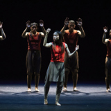 A dancer holds her hand up